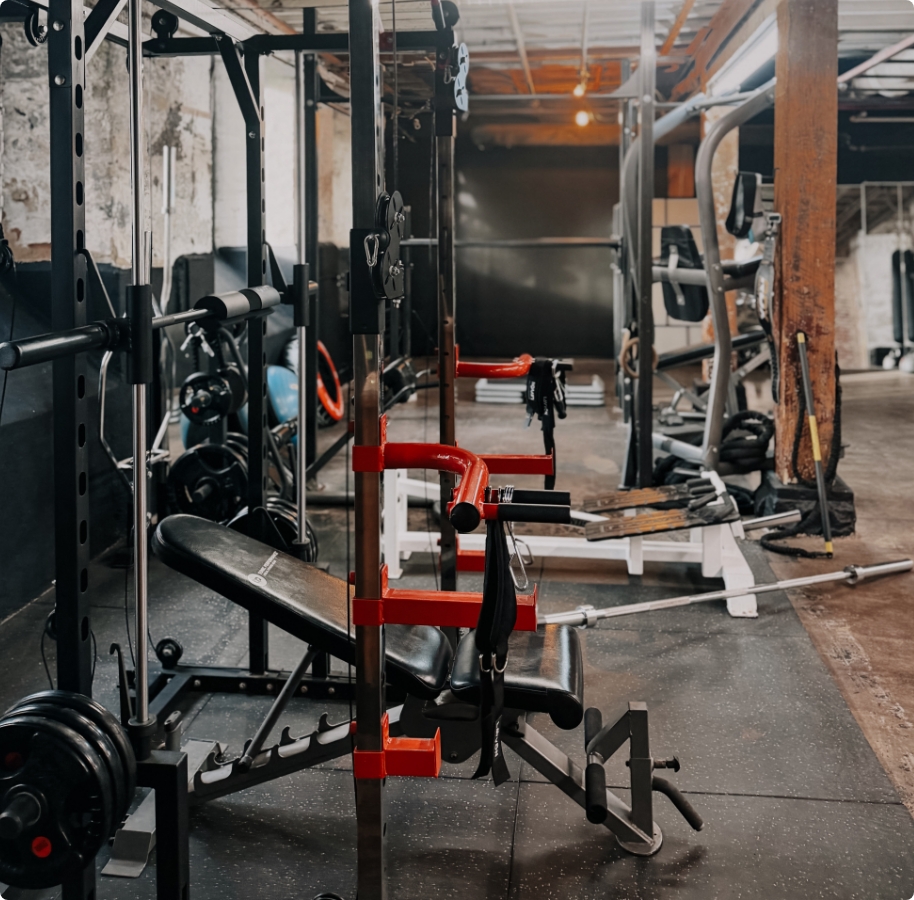 Private Gym B54 studio with training turf, brick walls, and suspension rings.